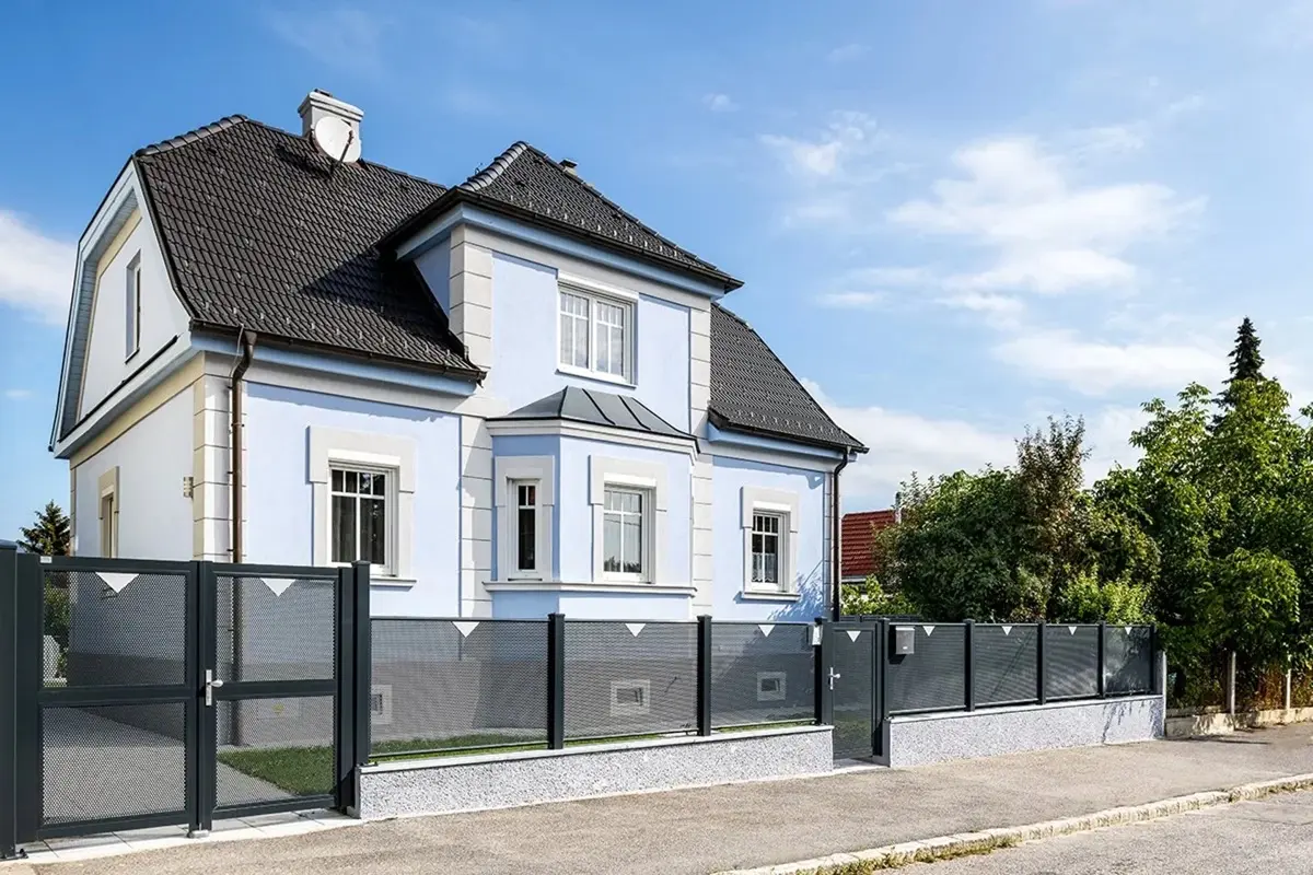 Aluminium-Zaun mit Lochblechfüllung und Gartentür vor einer Stadtvilla